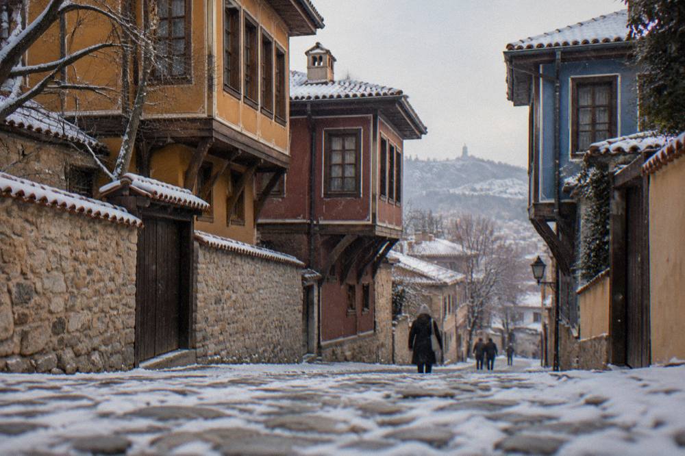 Snow-dusted cobbled street in Plovdiv Old Town with colourful revival-era houses on either side
