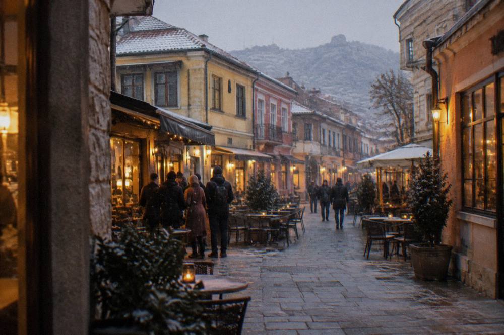 An evening street in the Kapana district with lit cafe windows and people talking outside
