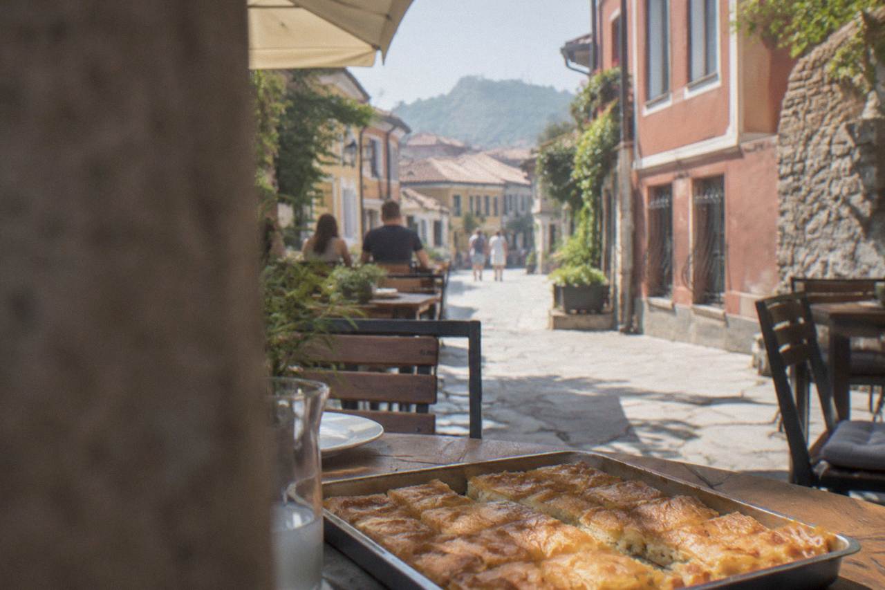 A tray of golden banitsa pastry sliced into squares on a cafe table