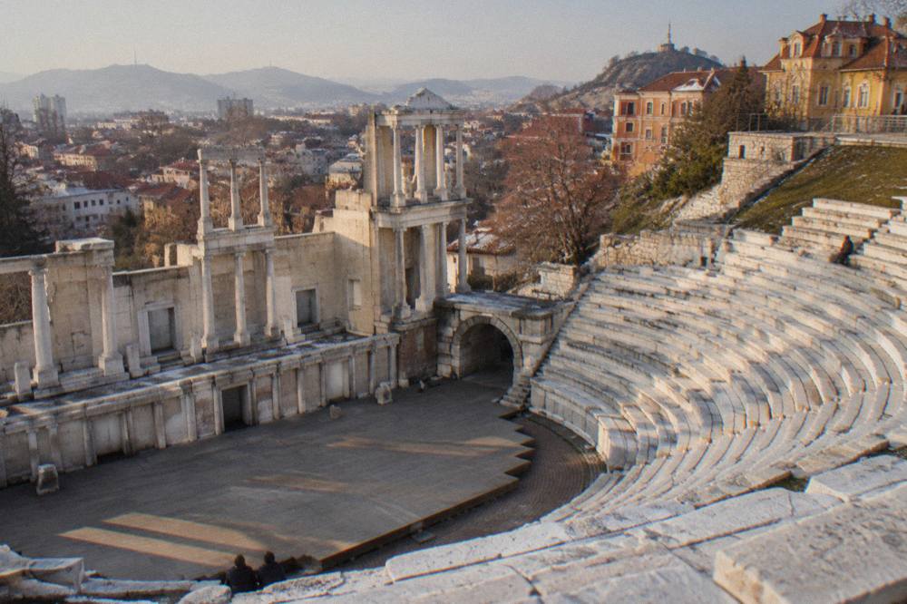 The marble seat rows of the Ancient Theatre of Philippopolis seen from the stage in warm afternoon light