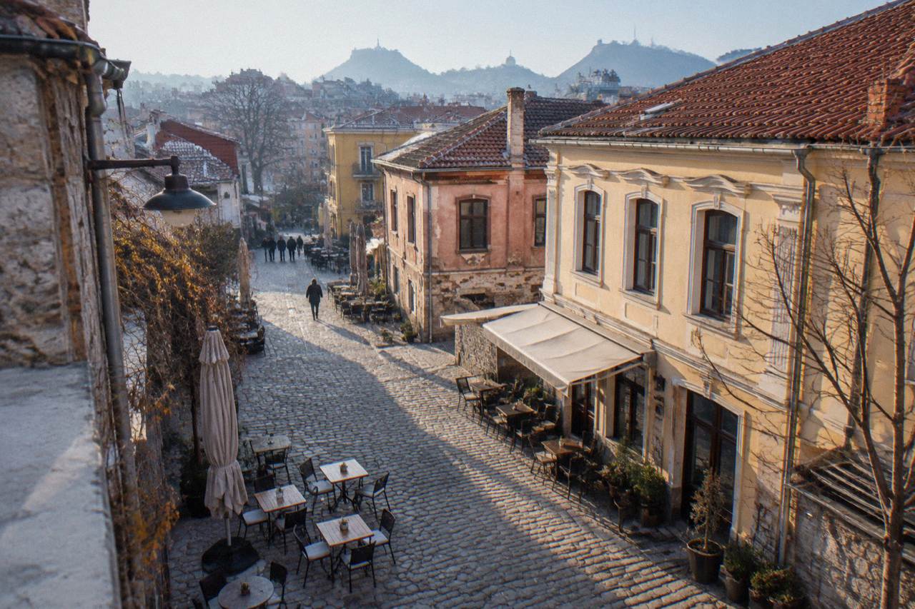 Outdoor cafe tables on a cobbled street in Plovdiv's Kapana district