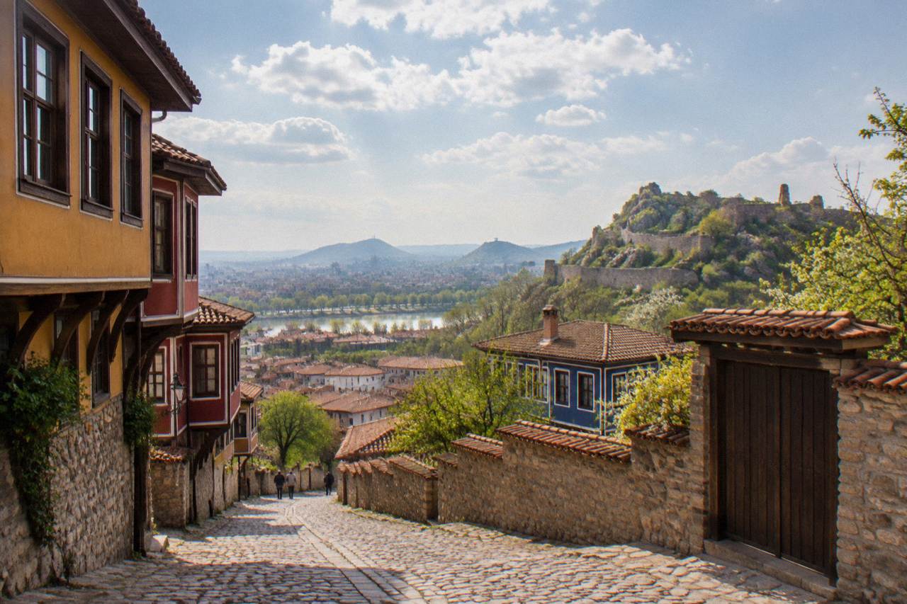 Ancient stone walls and archaeological foundations on a hill above red rooftops in Plovdiv