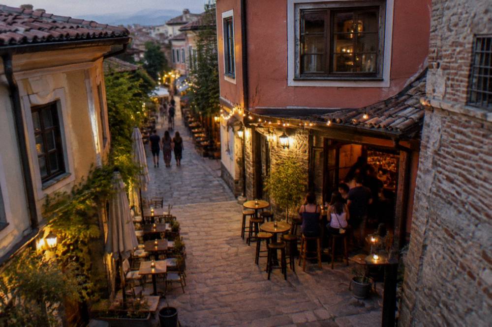 Evening lights and people at a bar entrance in a narrow Kapana lane