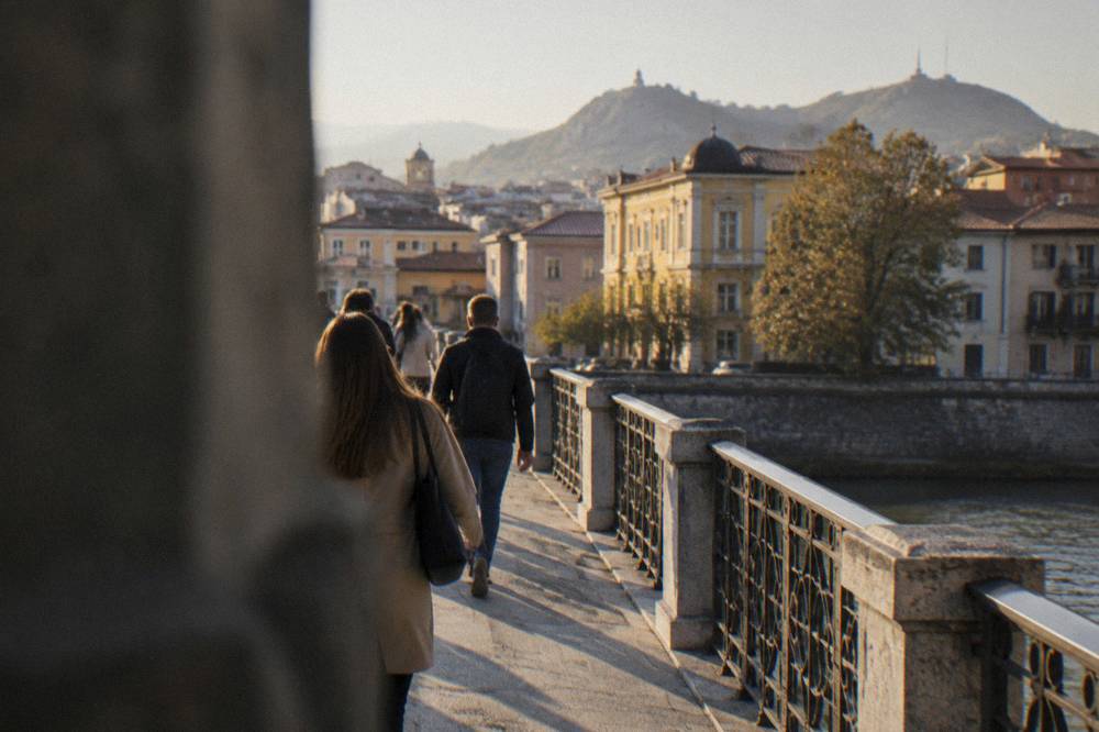 People walking on a bridge over the Maritsa with the city center behind them