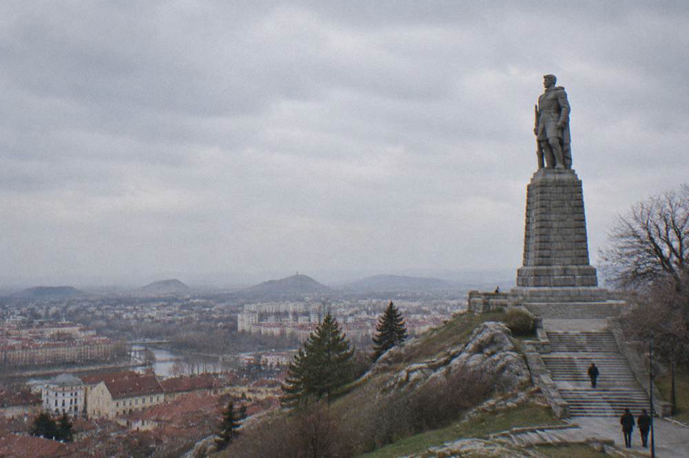 Soldier statue on a granite pedestal on a hill against the sky