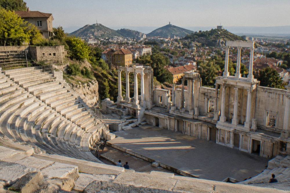 A semicircle of stone theatre seats facing a columned stage wall