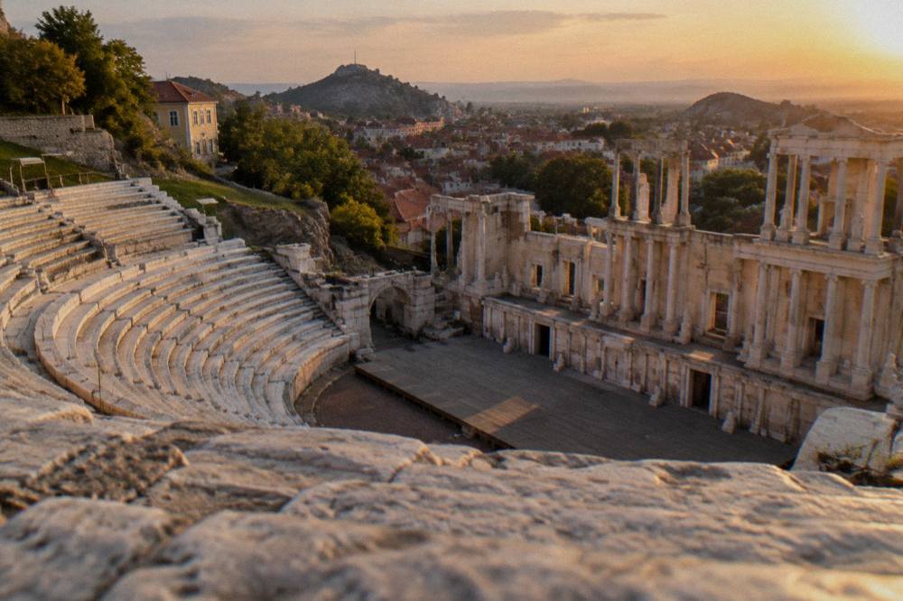 An ancient theatre at dusk lit by warm evening light