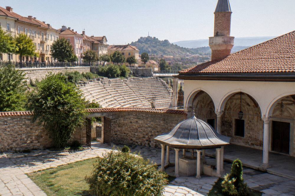 The courtyard of the Dzhumaya Mosque with the Roman Stadium stones visible beyond the wall