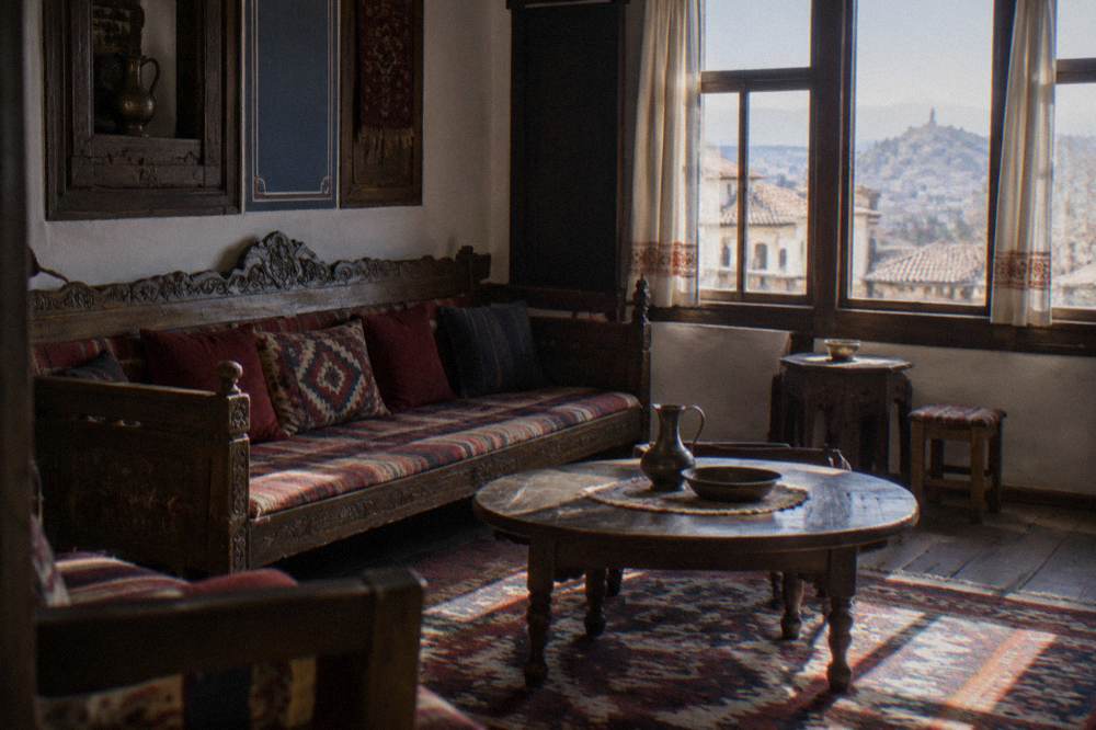A furnished period room with a carved wooden sofa, woven rugs and low tables in a Bulgarian revival house