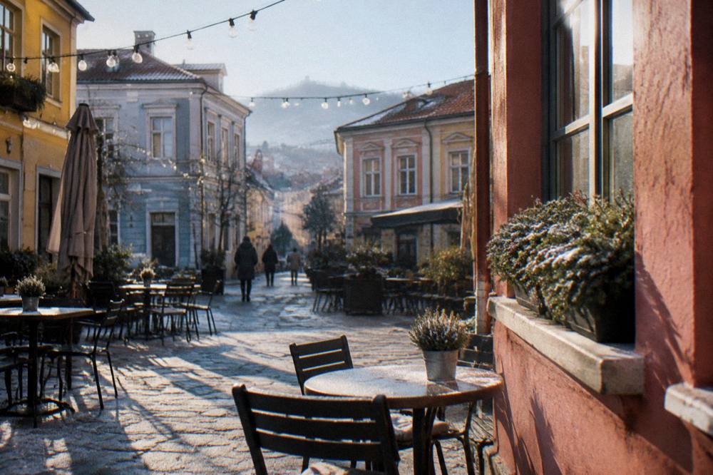 Small square in the Kapana district of Plovdiv with string lights, cafe tables and painted facades