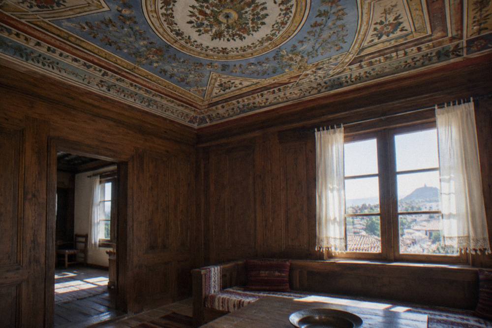 An ornately painted interior ceiling with floral decoration above a wooden room in an old Plovdiv house
