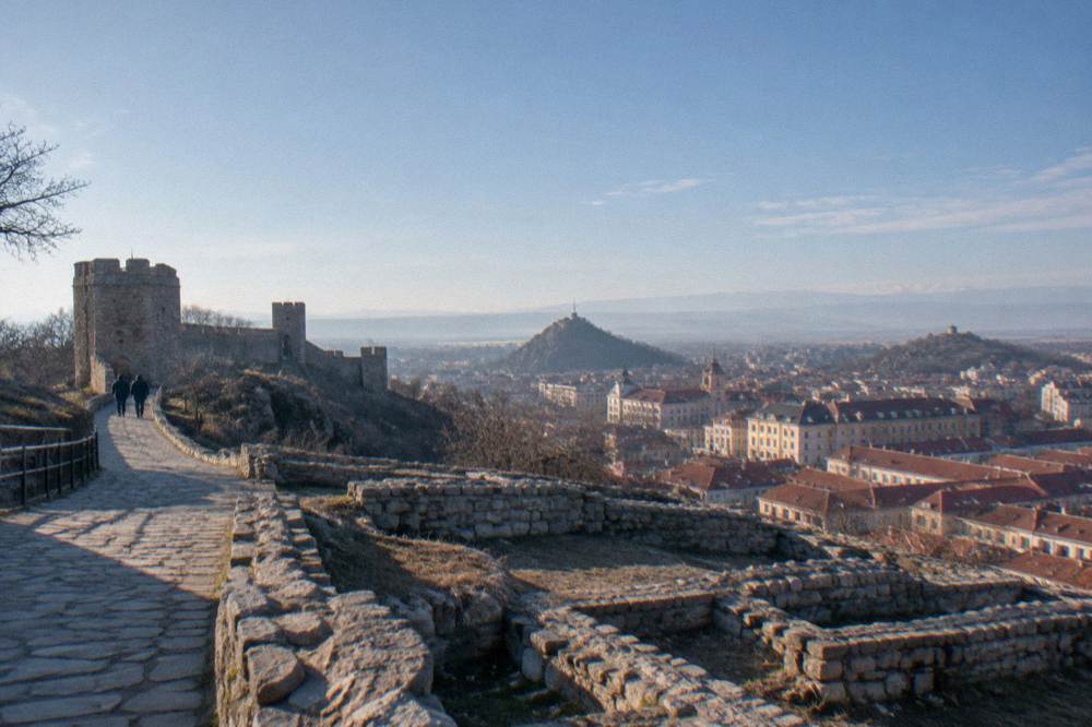 Open hilltop archaeological site with stone foundations