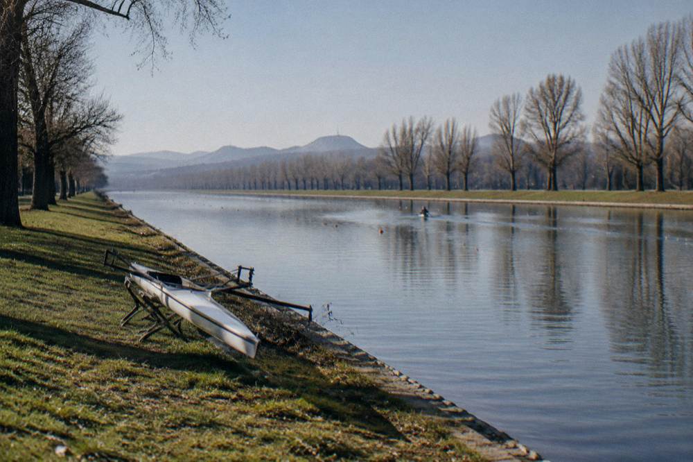 Long straight rowing canal with trees lining both banks and calm water