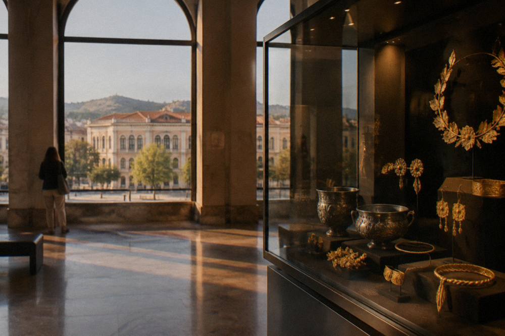 A display case of Thracian silver and gold ornaments lit against a dark background