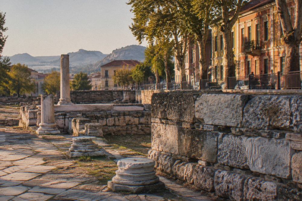 Weathered Roman stone wall with layered blocks standing beside a modern city street