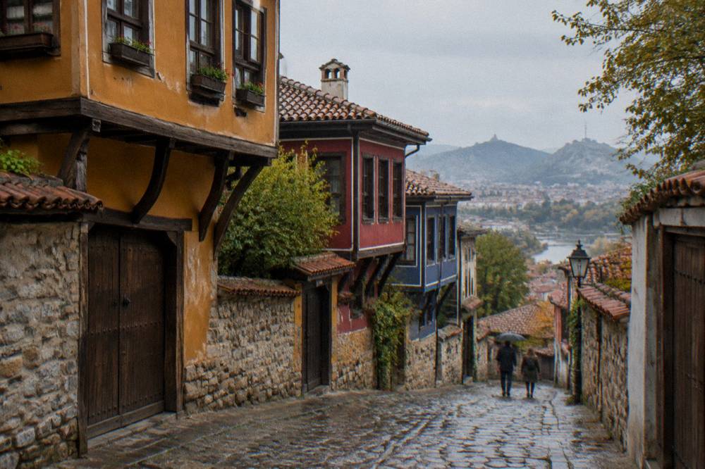 Narrow cobbled street in Plovdiv Old Town with colourful revival-era houses on the hillside