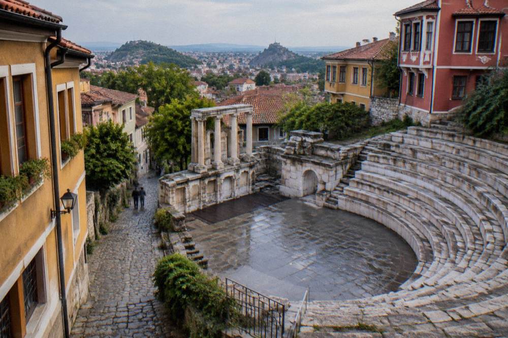 A stone-paved lane in Plovdiv's old quarter with coloured Revival-period houses rising on both sides