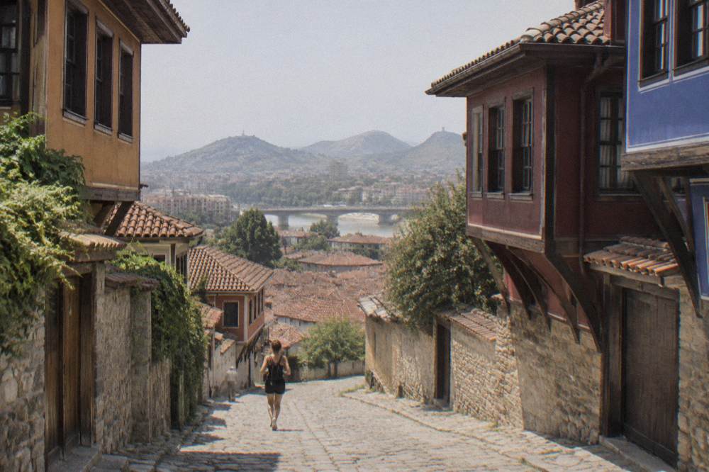 A panoramic view over the red rooftops of Plovdiv with hills on the horizon
