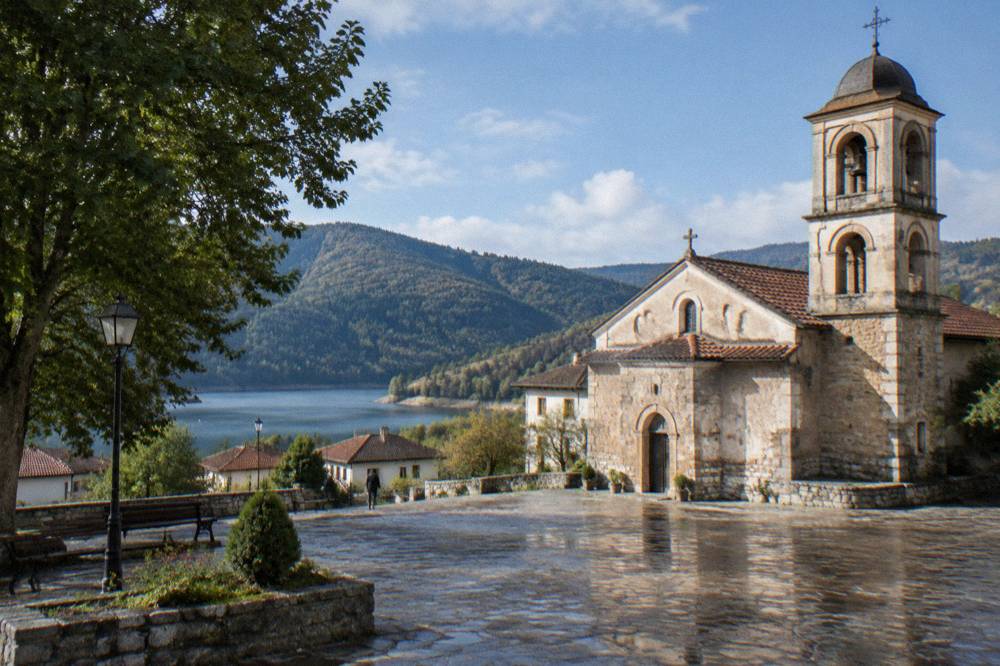 A stone church with a bell tower standing in a small town square