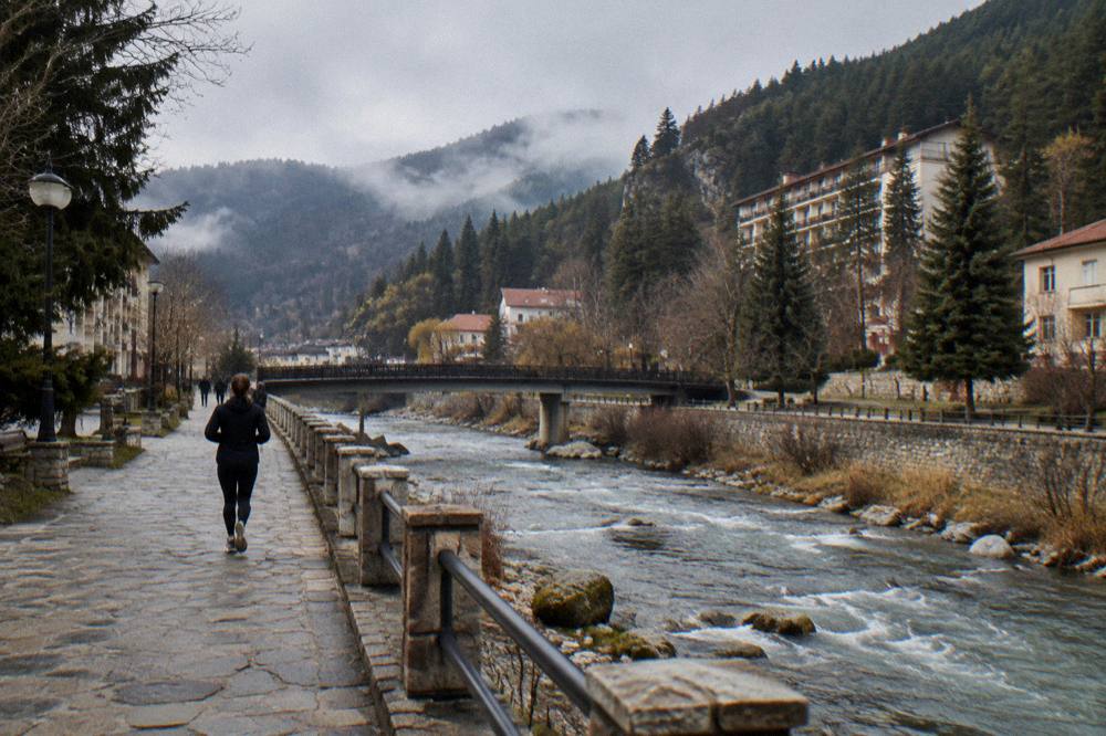 A hillside spa hotel with pine trees and morning mist over a valley