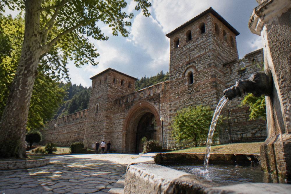 Mineral water flowing from a public drinking fountain into a stone basin