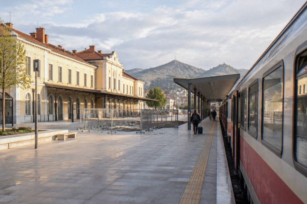 A regional train waiting at a Bulgarian railway station platform in morning light