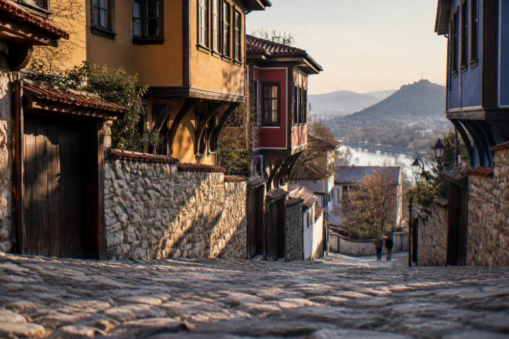 Old town street with colourful houses and cobbles in evening light