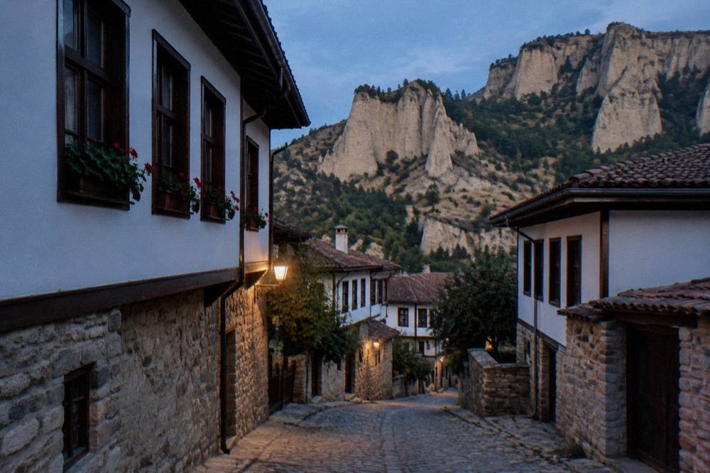 A narrow cobbled lane between restored Revival-era houses in Melnik