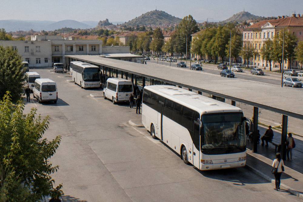 A regional bus waiting at a small Bulgarian bus station platform on a sunny morning