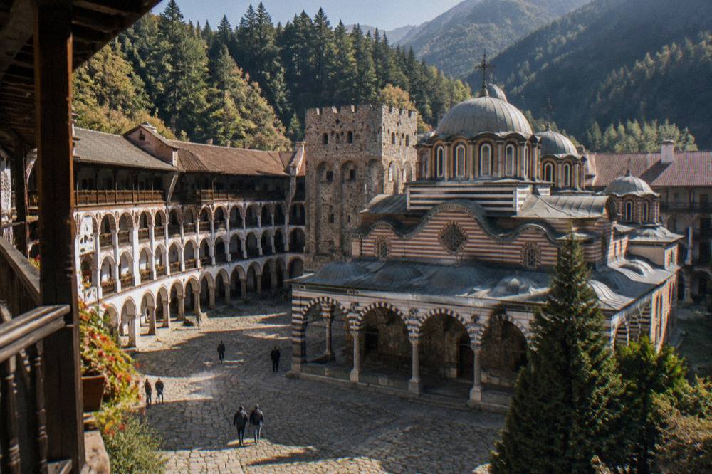 Monastery courtyard with arcaded galleries and a painted stone facade in the Rila Mountains