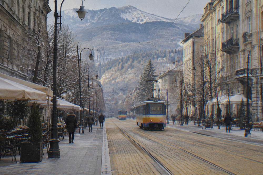 A city street in Sofia with trams, wide pavements and yellow cobblestone road surfaces
