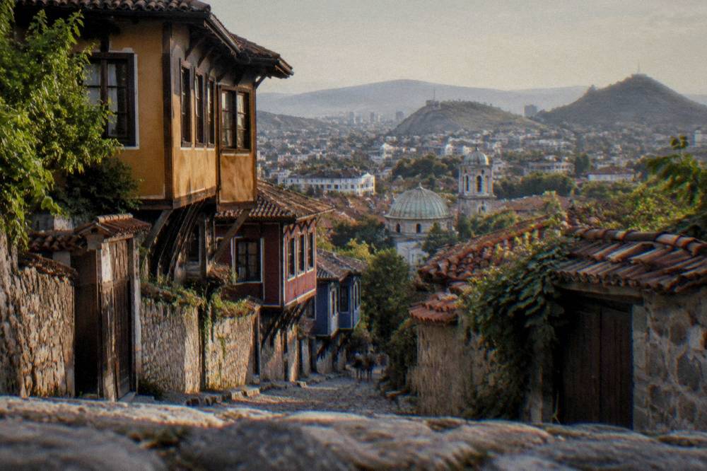 An evening view over Plovdiv's Old Town rooftops with church domes and hillside houses