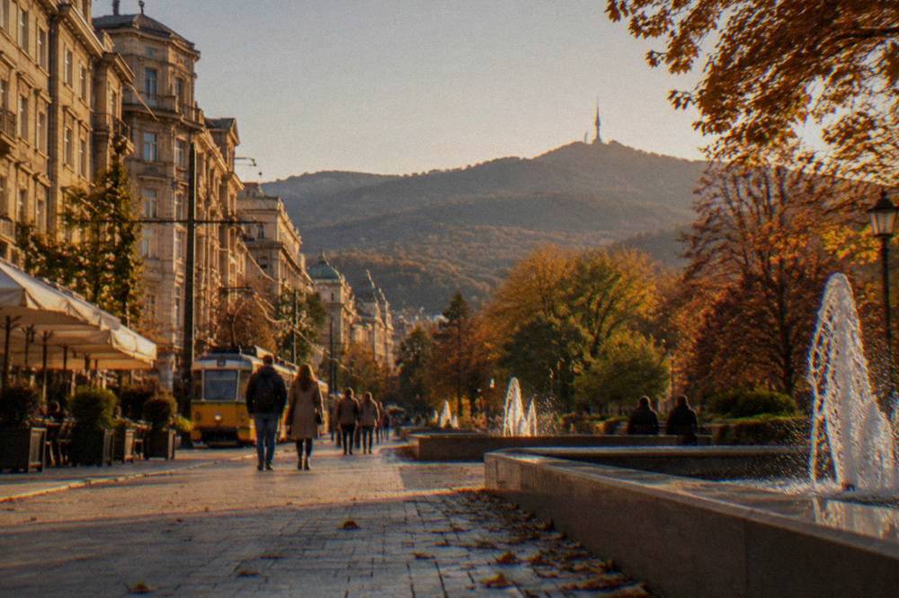 A park in a Bulgarian city in autumn colour with fountain basins and people strolling