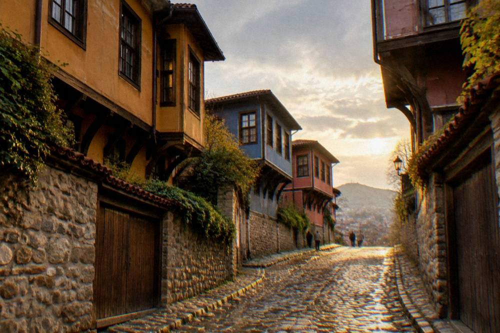 Cobblestone street with colourful old houses in a Bulgarian old town at golden hour