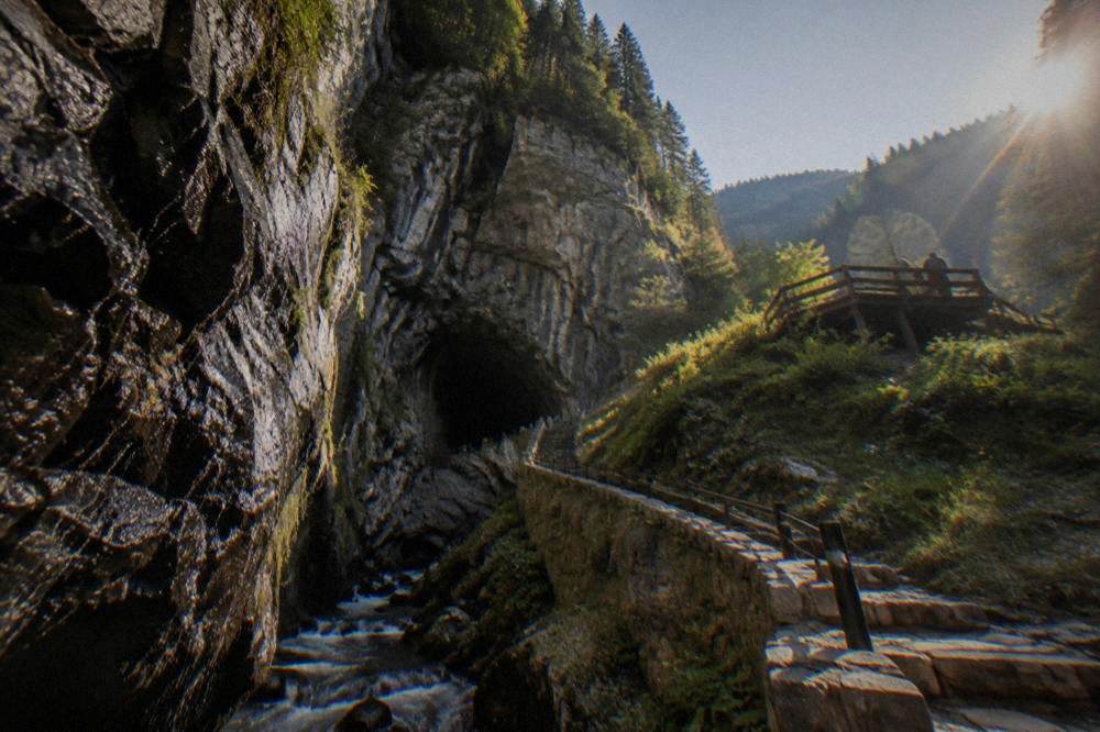 A wooden viewing platform on a green mountain slope overlooking forested Rhodope ridges