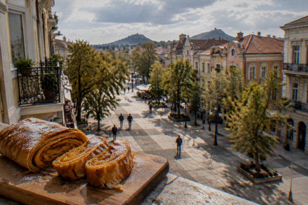 Rolled sweet tikvenik pastry with pumpkin filling sliced on a wooden board