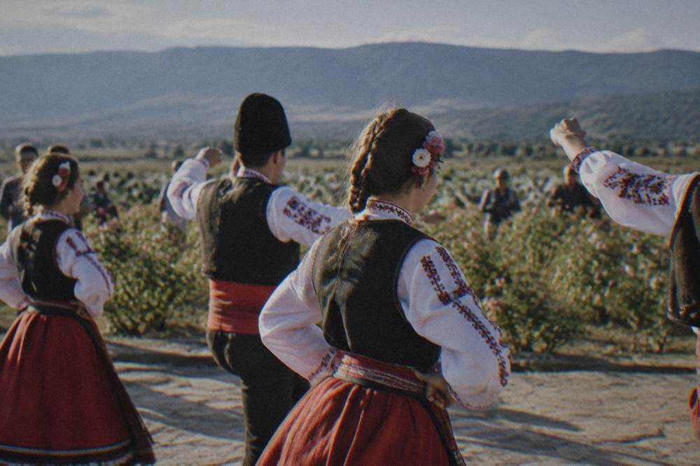 Dancers in Bulgarian folk costumes performing at an outdoor festival