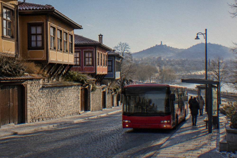 A red city bus stopping at a bus stop on a boulevard in central Plovdiv