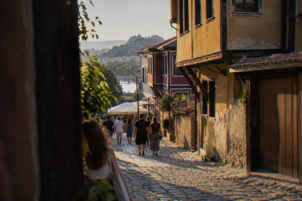 Visitors walking along the pedestrian Main Street in Plovdiv past shopfronts and cafes