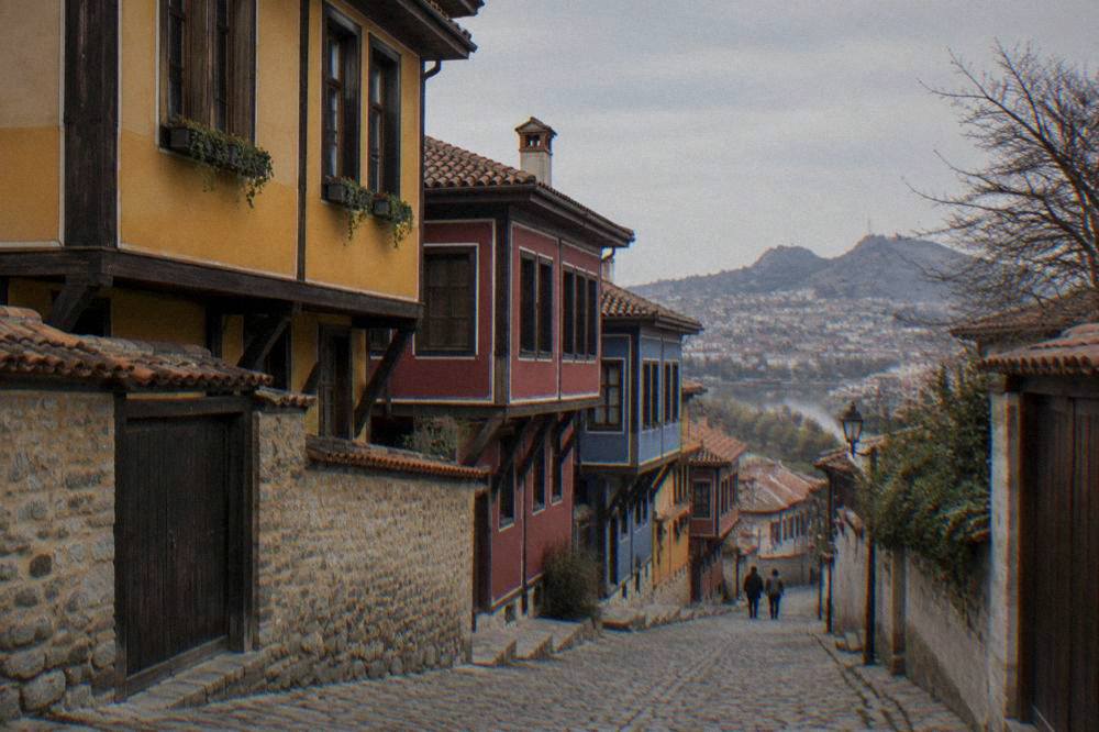 A cobbled street in an old town with colourful revival-era houses