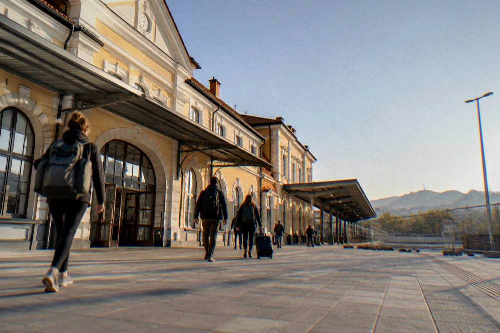 Travellers with backpacks walking out of a railway station entrance