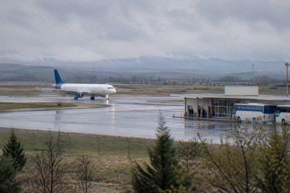 A low-cost airliner taxiing on a quiet runway at a small Balkan airport