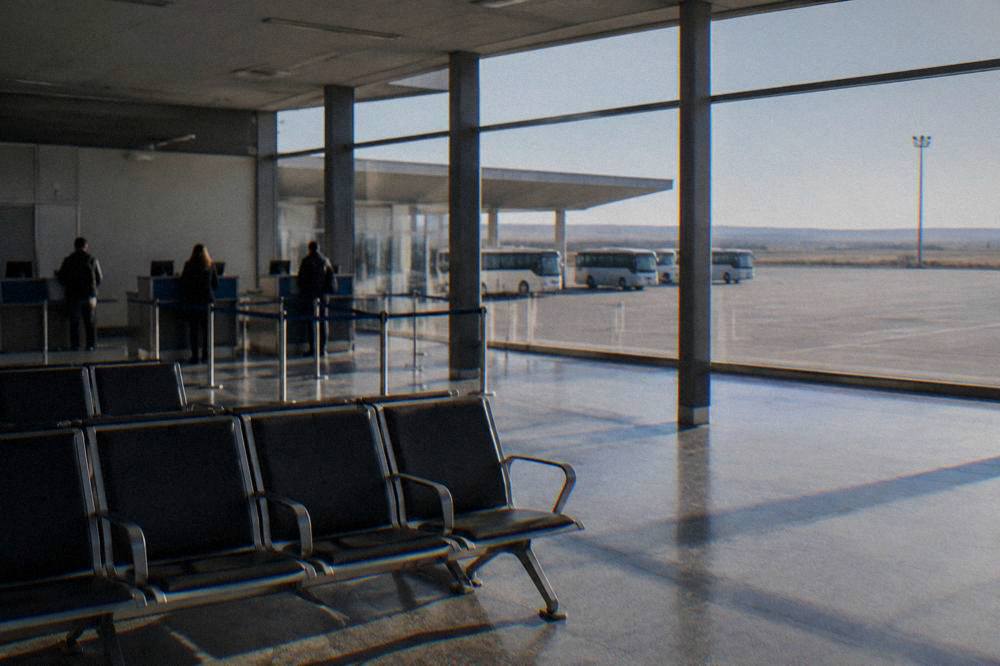 A quiet departures hall with a few check-in desks and empty seating