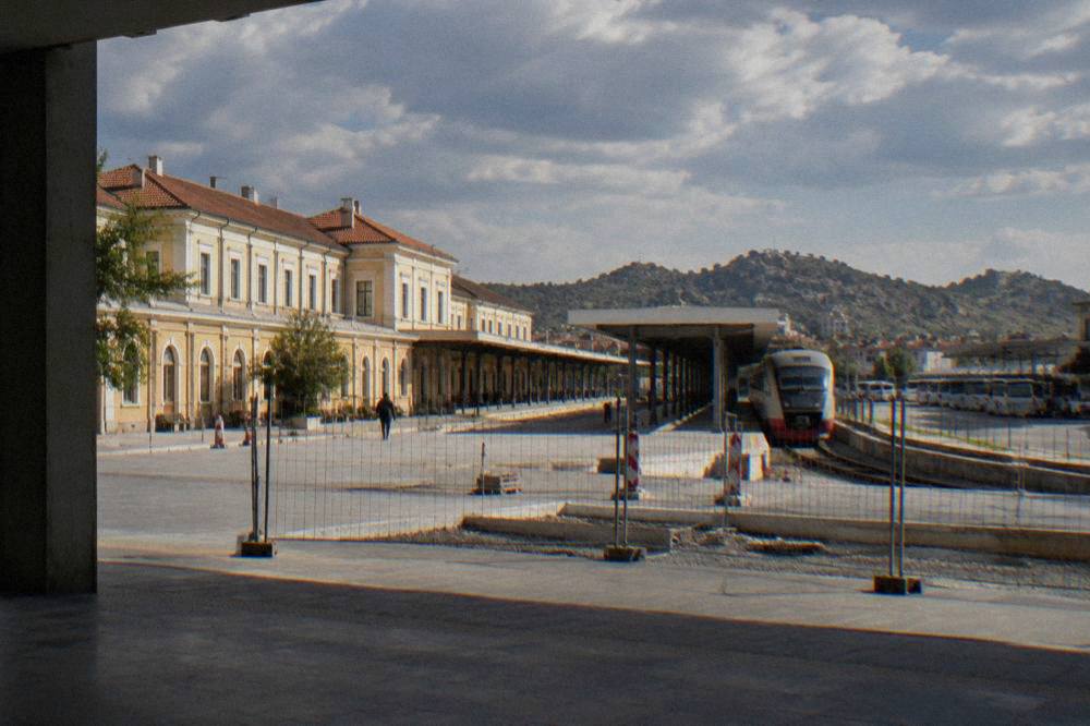 A passenger train waiting at Plovdiv central railway station platform beside the bus station