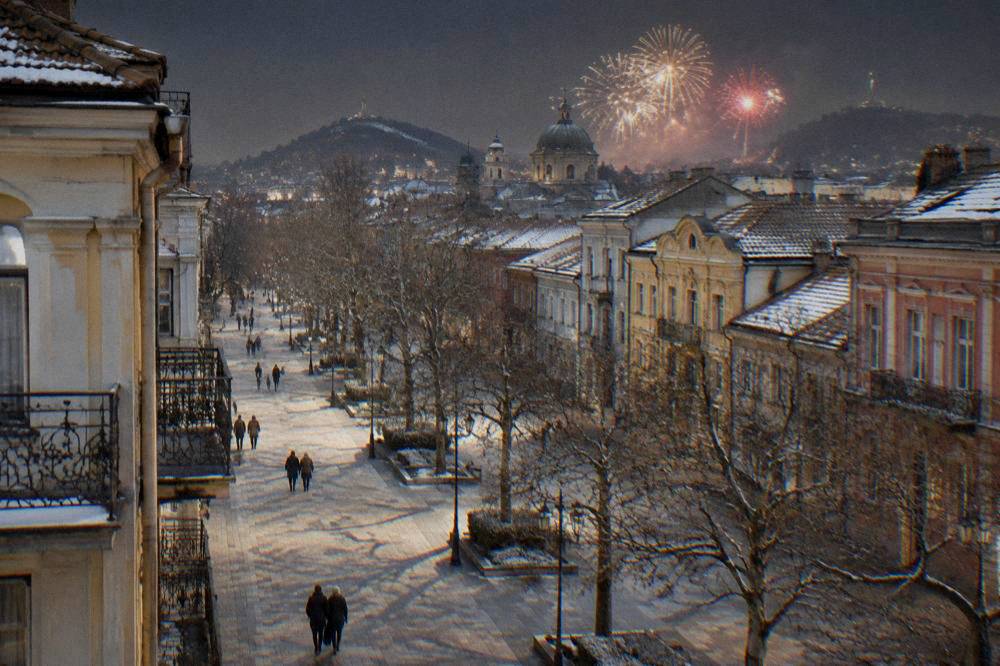 Fireworks bursting over a city skyline of church domes and hills at midnight