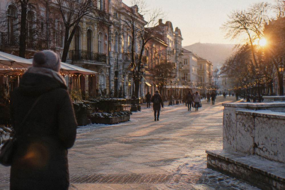 Pedestrian square with warm festive lights at dusk