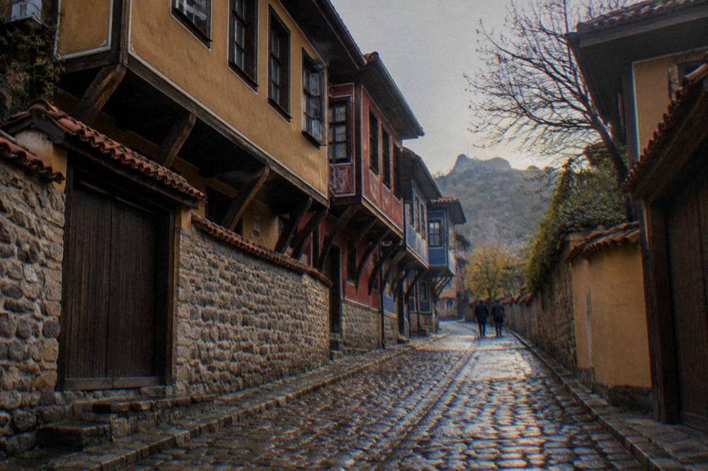 A cobbled Old Town street lined with colourful 19th-century houses in late afternoon light