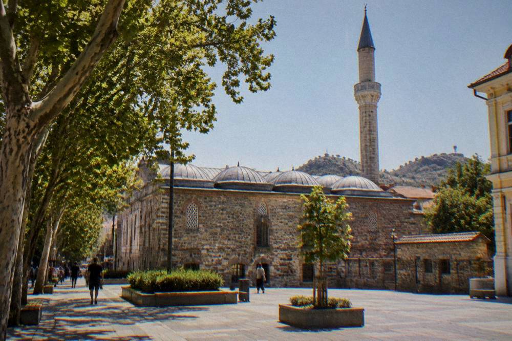 Minaret and walls of the Dzhumaya Mosque beside a modern pedestrian square