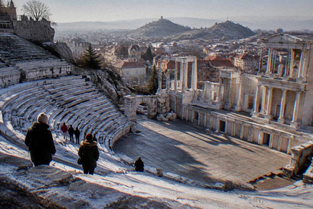 Visitors standing among the marble rows of the Ancient Theatre of Philippopolis