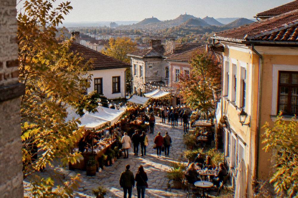 Crowd at an outdoor autumn festival in Kapana with food stalls and string lights